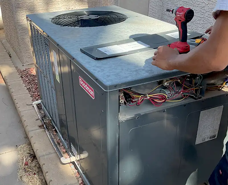 Eagle Air Technician Repairing a Goodman HVAC System in Chandler, AZ